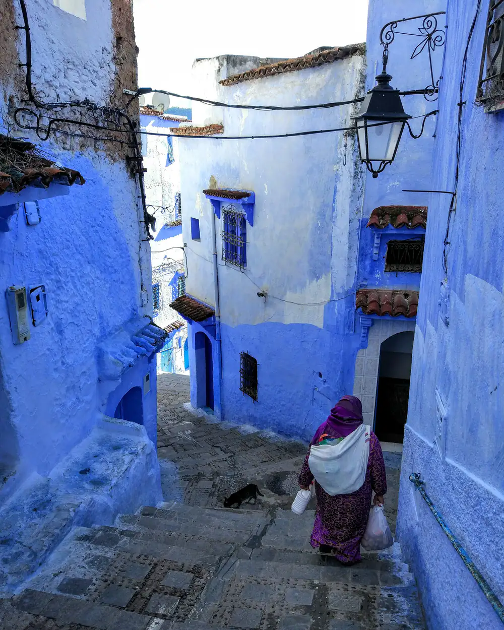 A blue-painted stairway and lamp in the medina of Chefchaouen