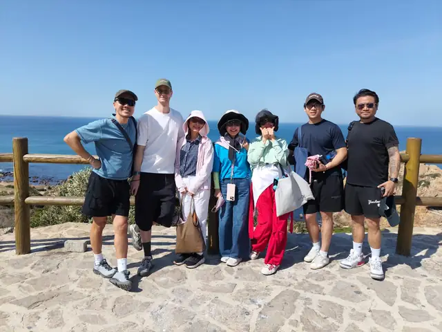 A group of cruise passengers on a private tour at a viewpoint over the Atlantic near Tangier